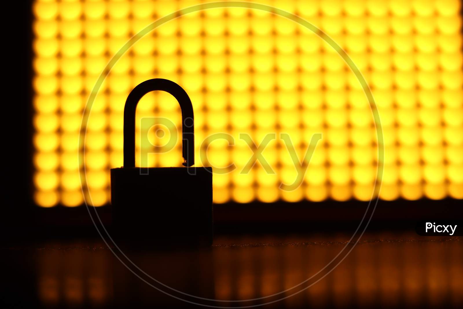 A silhoutte of a lock in an contrast yellow background