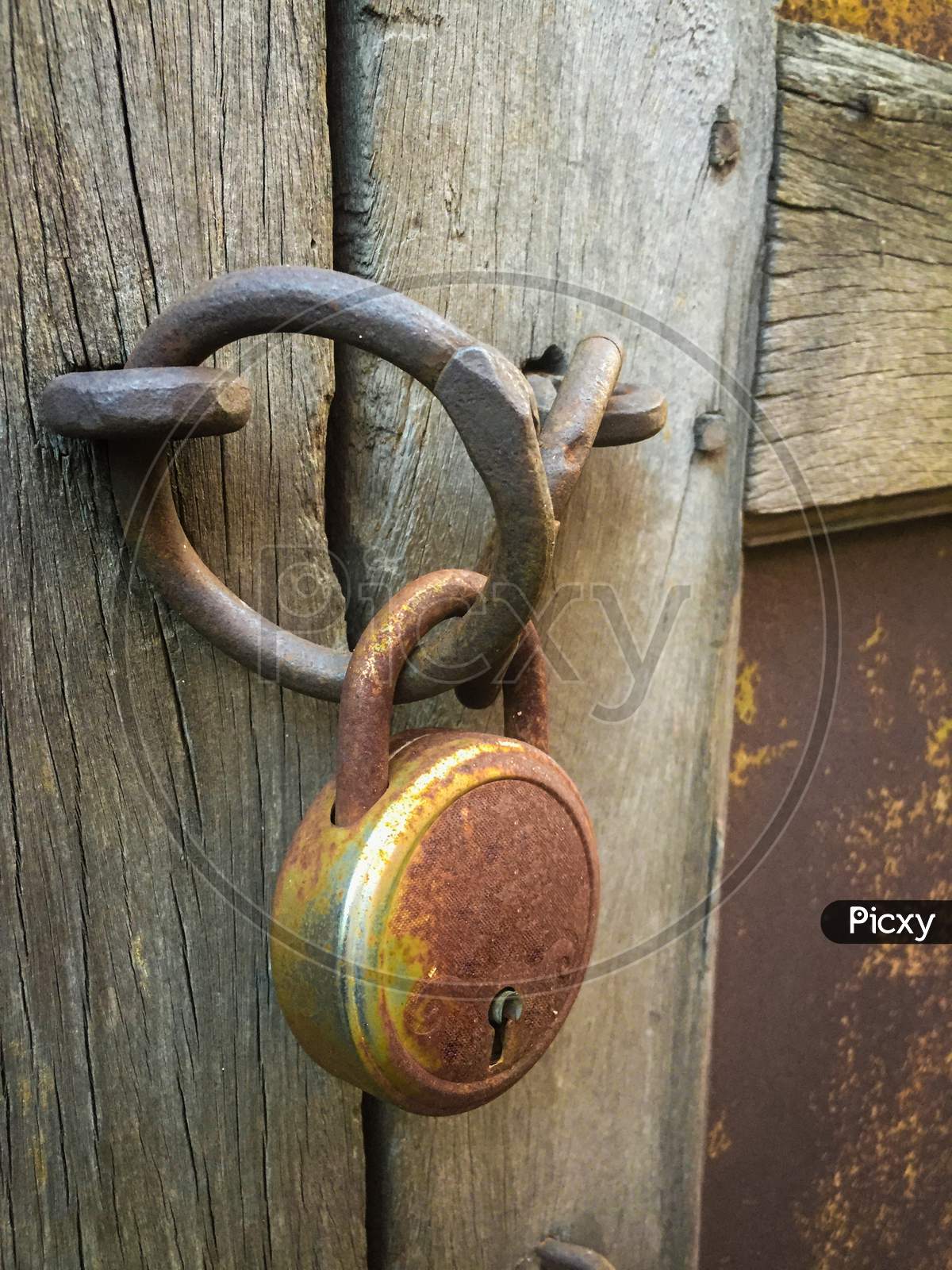 India - May 8, 2020: old lock on a wooden gate, with raw background