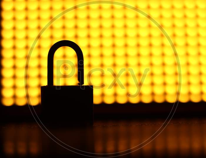 A silhoutte of a lock in an contrast yellow background