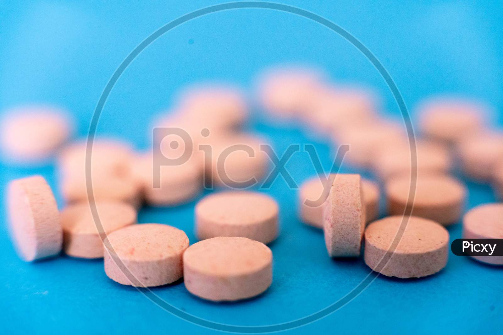 Selective Focus Shot Showing Tablets, On Blue Showing The Antiviral Cure For Coronavirus Covid19 Pandemic Ravaging The World