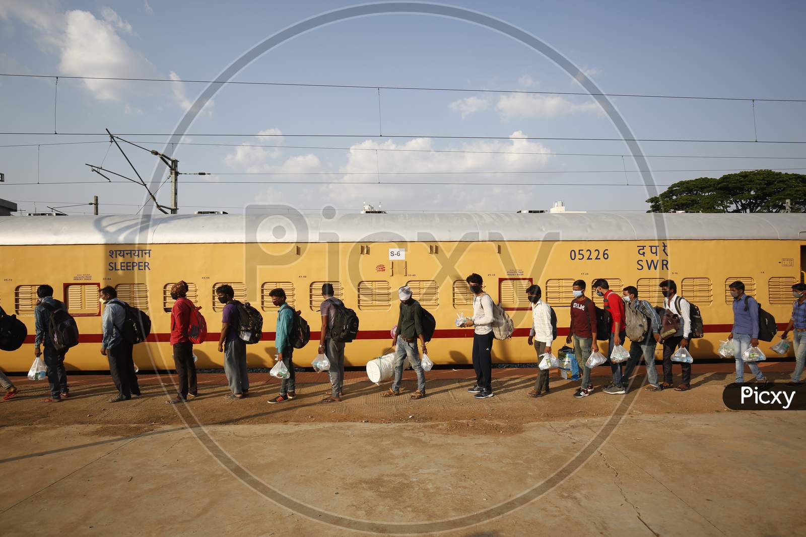 Men queue to board a train to travel to Danapur, Bihar in a special train arranged by the government to repatriate migrant workers at the Chikkabanavara Junction Railway Station on the outskirts of Bangalore, India.