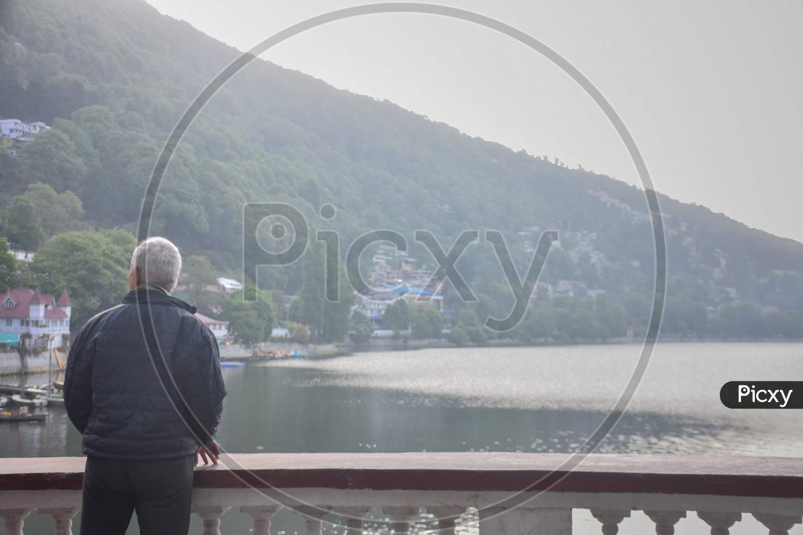 Nainital/India - May 7, 2020: old man standing near the lake in mountain, and feel fresh air in nainital