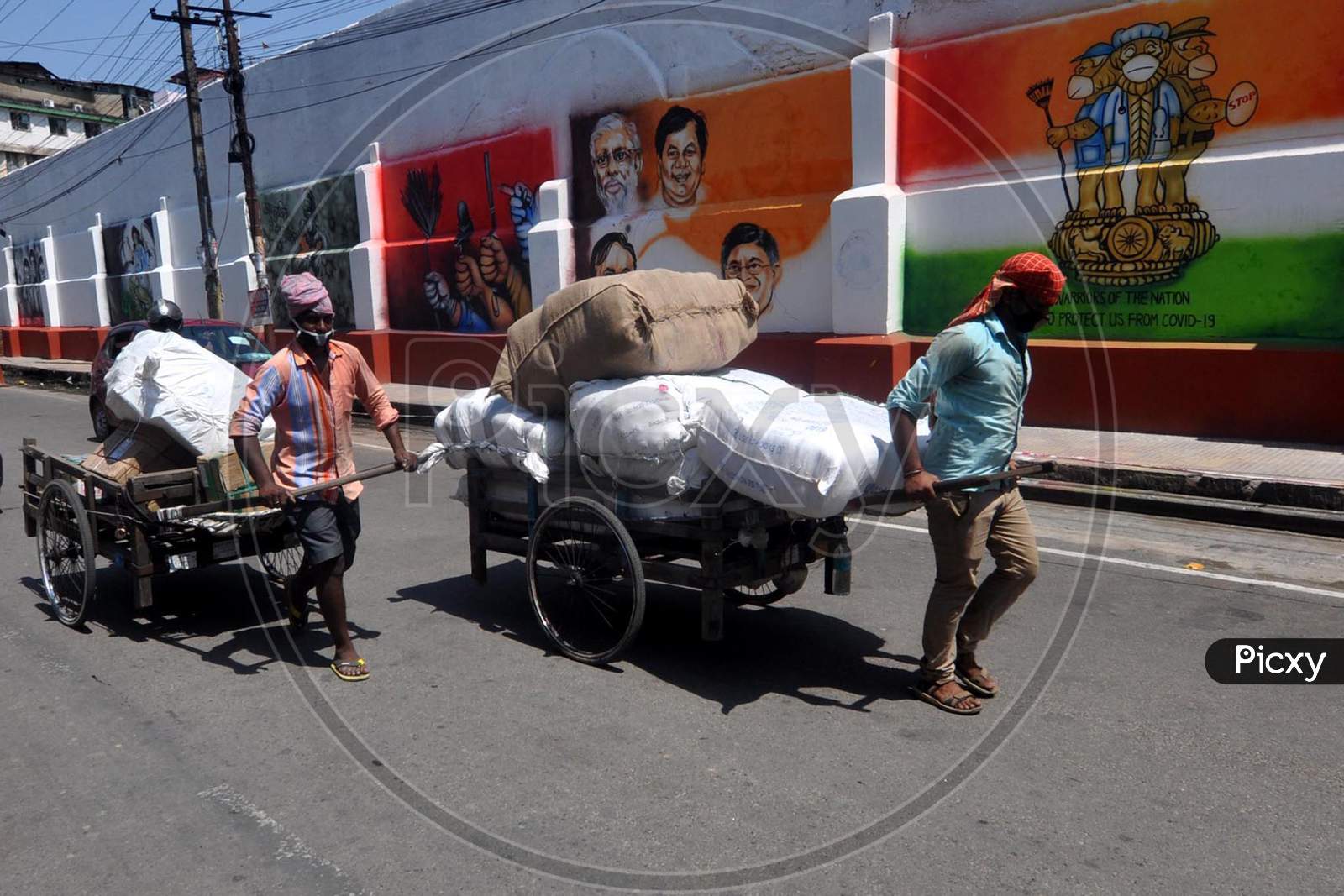 Labourers Carry Essentials Past A Mural,During Nationwide Lockdown Amidst Coronavirus Or COVID-19 Pandemic  In Guwahati, Saturday, May 09, 2020