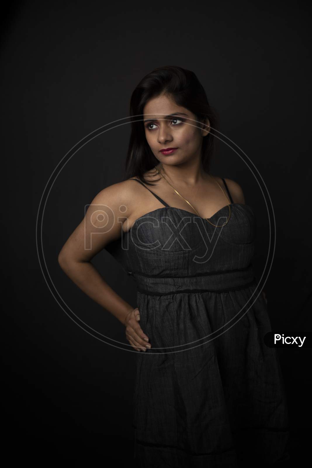 Fashion portrait of an young Indian Bengali brunette woman in black inner  wear and western jacket standing in front of a window in studio background.  Indian lifestyle and fashion photography. Stock Photo