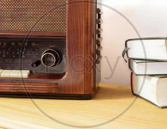Vintage radio made of wood and old books on a table