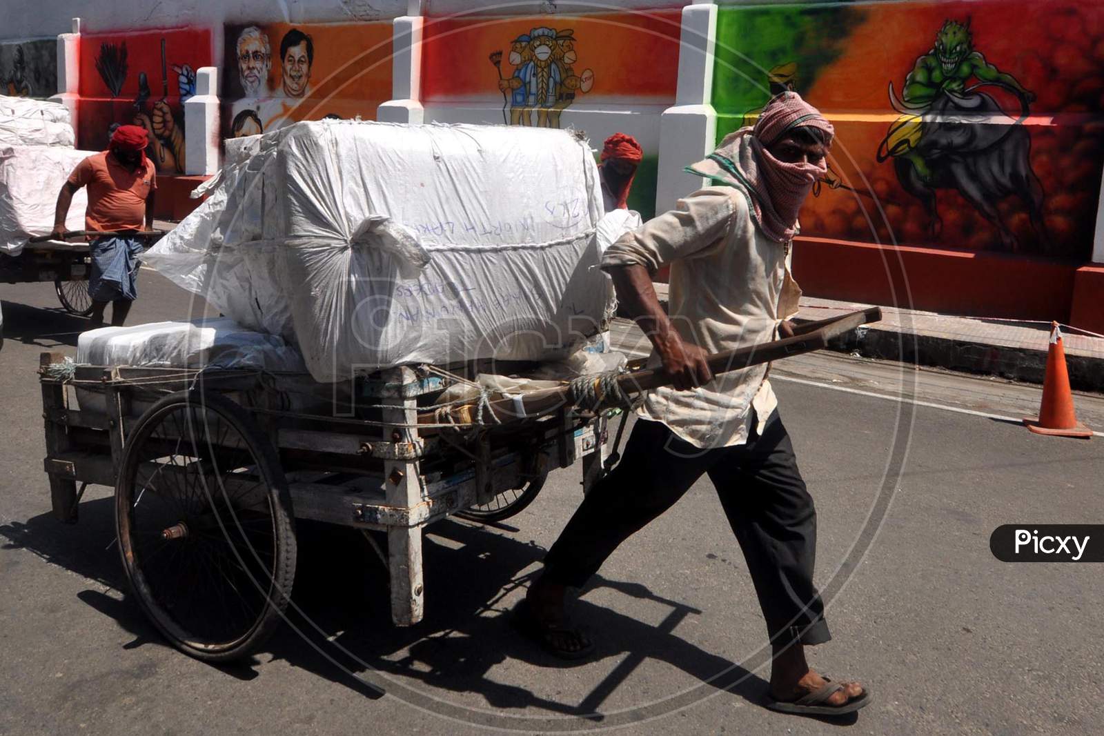 A Labour Carries Essentials Past A Mural,During Nationwide Lockdown Amidst Coronavirus Or COVID-19 Pandemic  In Guwahati, Saturday, May 09, 2020