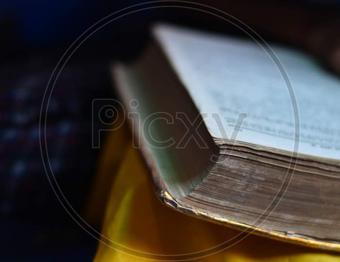 India - May 09, 2020: closeup of a Indian girl reading a holy ramayan and bhagwat geeta at home, with blur background.