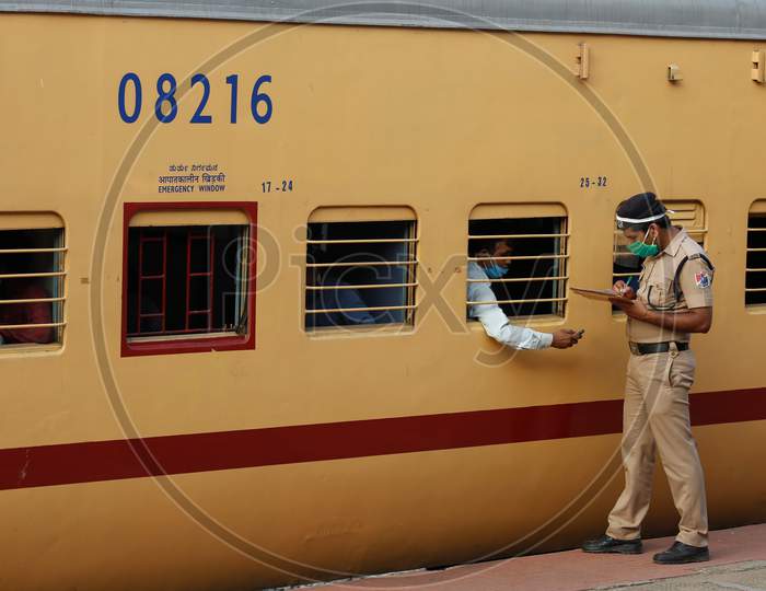 A Railway Protection Force (RPF) personnel checks travel documents of migrant workers travelling to Danapur, Bihar in a special train arranged by the government to repatriate migrant workers at the Chikkabanavara Junction Railway Station on the outskirts of Bangalore, India.