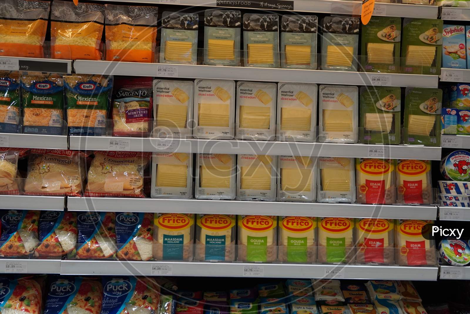 Different Types Of Cheese On Shelves In A Grocery Store. Shelf Of Packaged Products, Butter And Cheese At A Market. Cheddar, Edam, Mozzarella, Gouda, Blue Cheese.