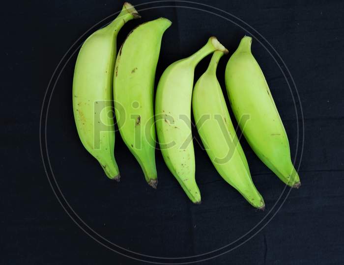 beautiful green banana isolated in black background