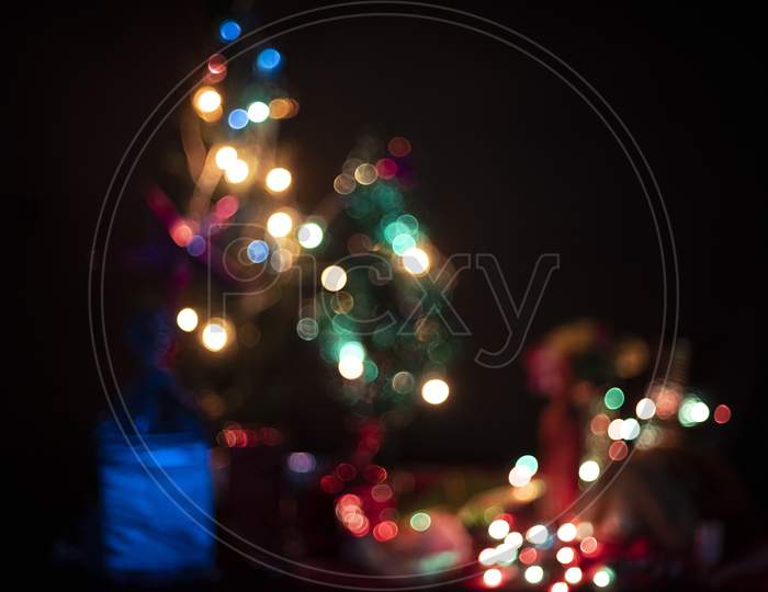 Blurred image of a decoration with Christmas trees, lights, gifts,toys, Santa Clause, candles for the celebration of Christmas and new year. Indian lifestyle and Christmas celebration.