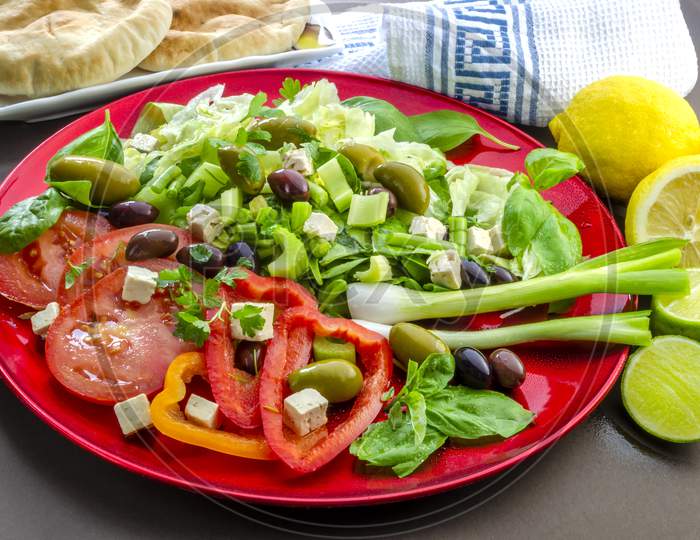 traditional salad on a red plate with lemon dressing.