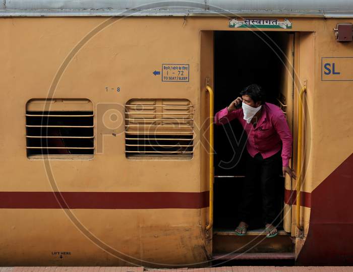 A man looks out of the door as he travels to Danapur, Bihar in a special train arranged by the government to repatriate migrant workers at the Chikkabanavara Junction Railway Station on the outskirts of Bangalore, India.