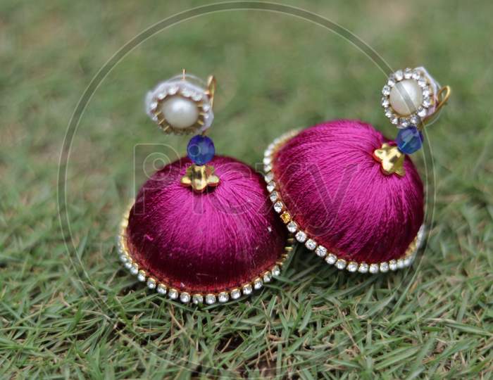 Handmade Colourful Earrings On Green Lawn Grass Background