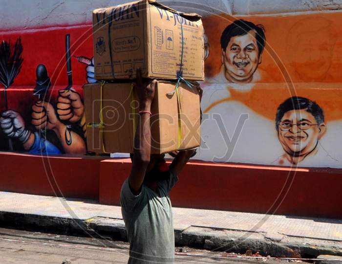 A Labourer Walks Past A Mural, During Nationwide Lockdown Amidst Coronavirus Or COVID-19 Pandemic , In Guwahati, Saturday, May 09, 2020.