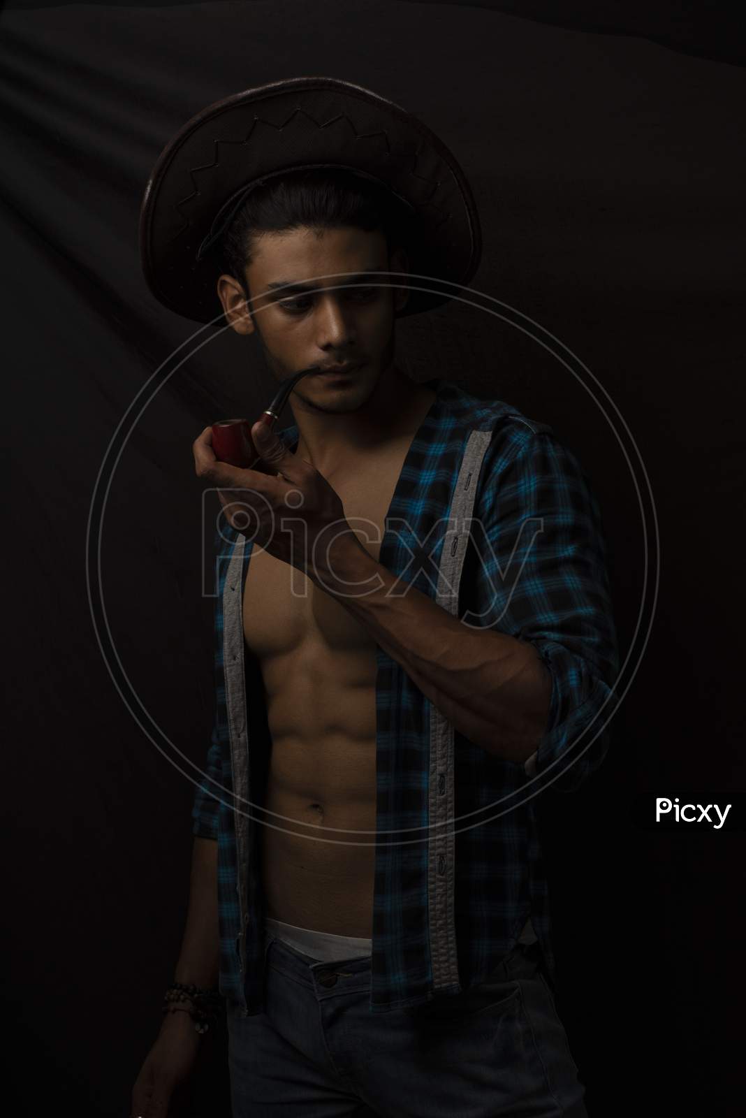 Image of Portrait of an young and handsome brunette Bengali muscular man in  open shirt in front of black background. Indian lifestyle.-BG853157-Picxy