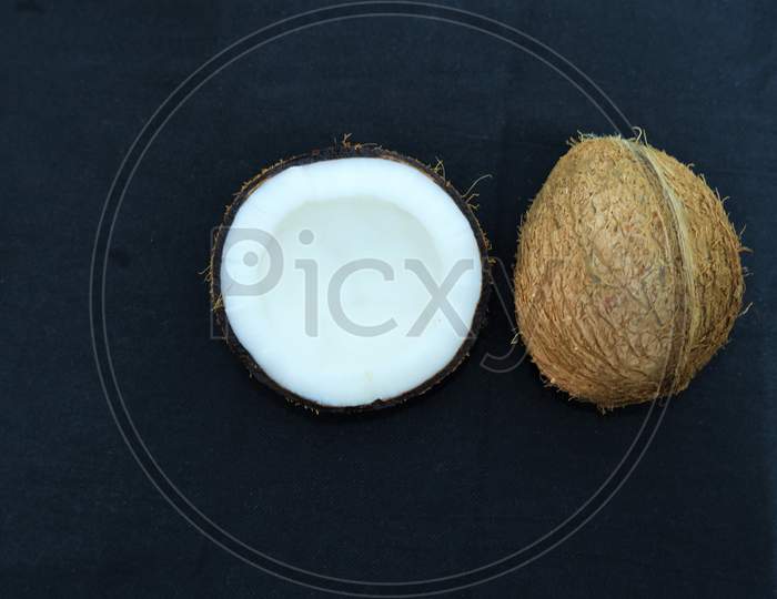 Coconut and half piece in black background