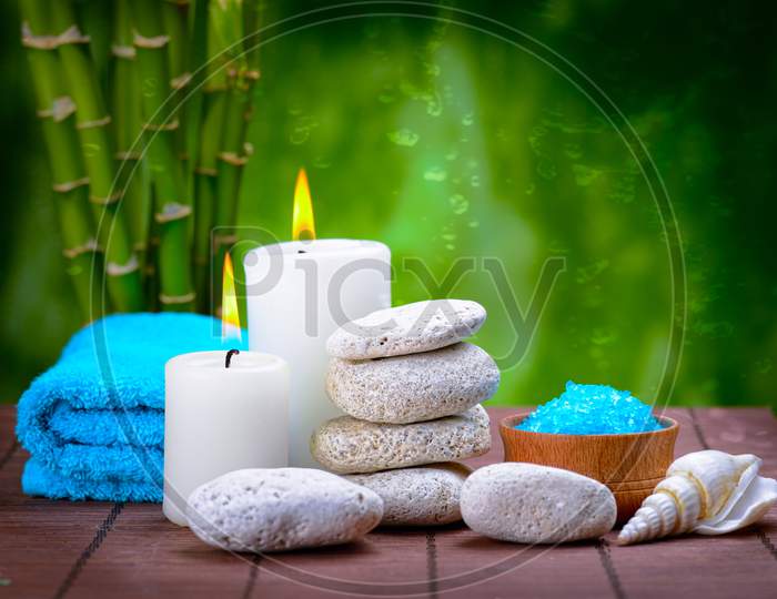 White candle  grey stone with a blue towel for background