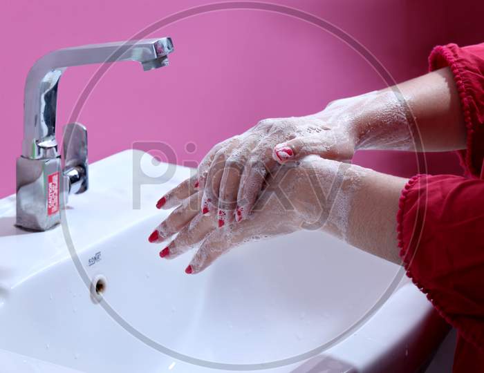 A young girl washing her hands