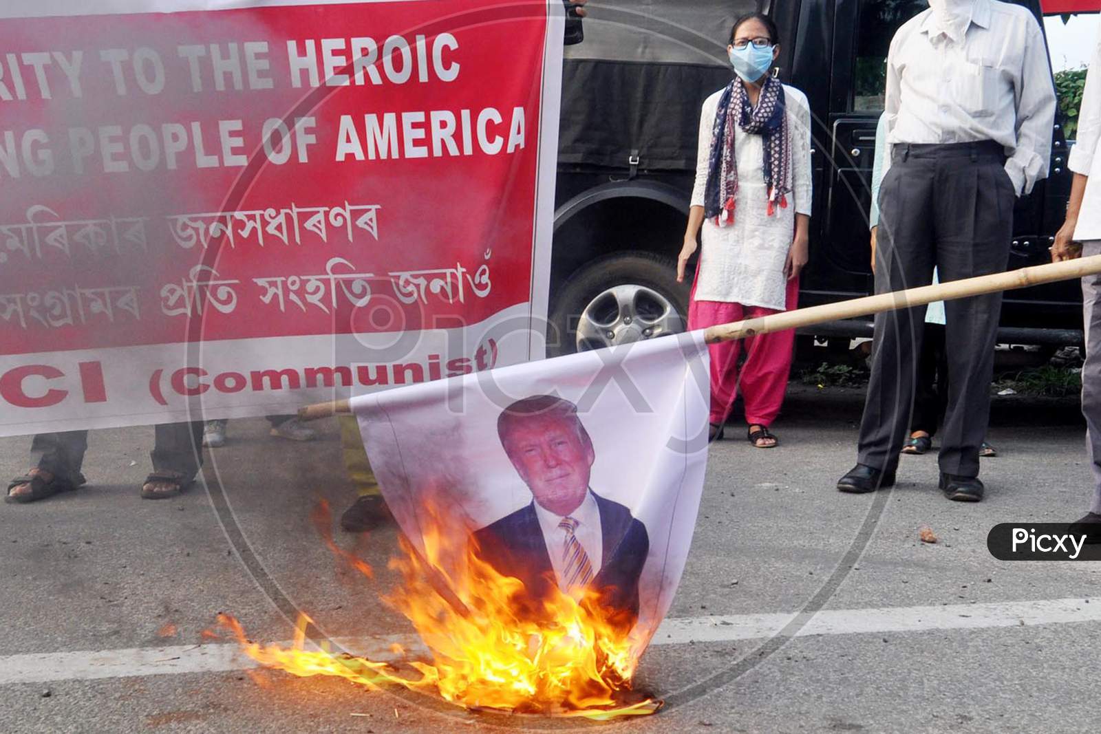 Activists Of Socialist Unity Centre Of India (Communist) Burning The Poster Of Donald John Trump, President Of The United States During The Protest Demonstration against the killing in USA, In Guwahati, On June 1, 2020