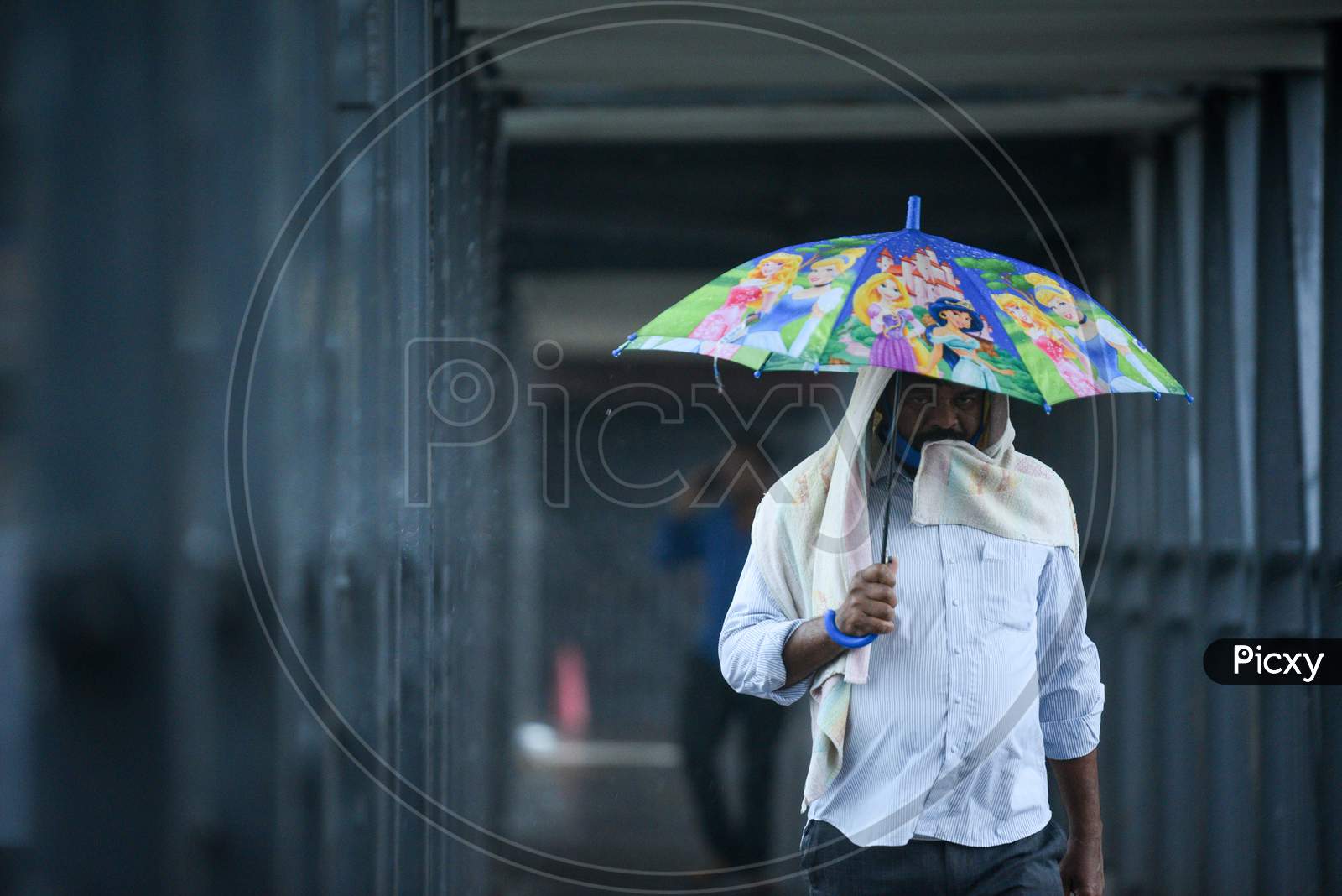 A man carries an umbrella as he walks on a foot over bridge, May 31, 2020.