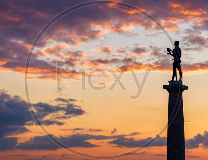 Silhouette of Victor monument with colorful sunset in the background, Belgrade