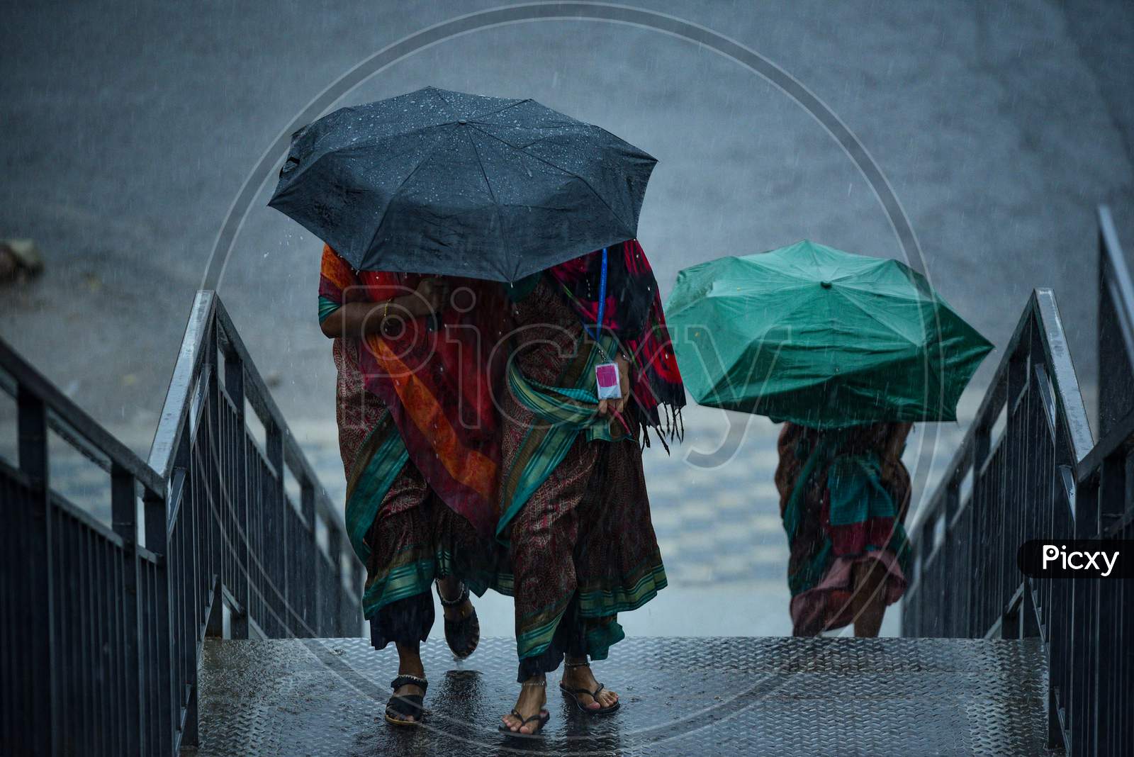 Women walk under an umbrella as it rains Heavily in KPHB,Hyderabad, May 31, 2020