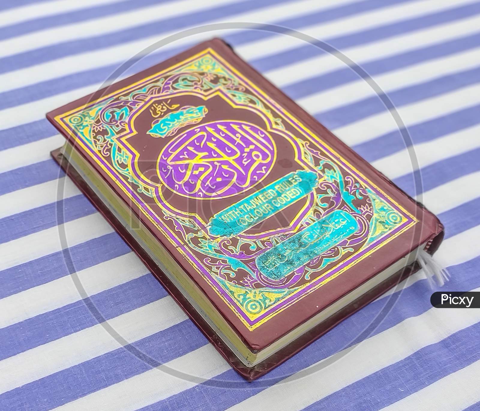 Cover photo of Quran with striped background.