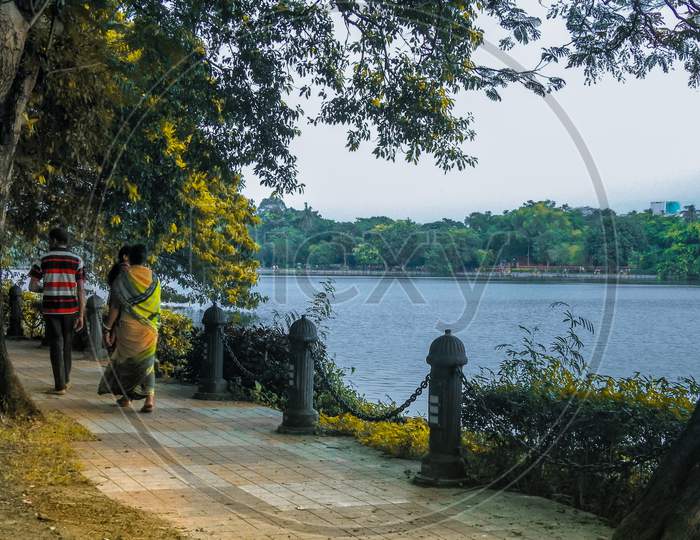Rabindra sarobar, Kolkata, West Bengal, India. September 14, 2019. The people are walking alone the shore of the lake.