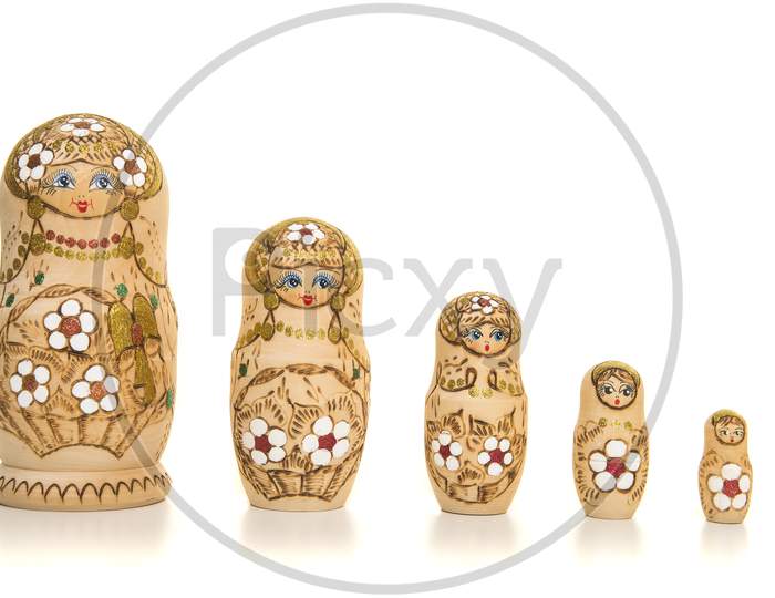 Set Of Five Wooden Matryoshka Dolls Standing In A Row, From Large To Small Isolated On A White Background