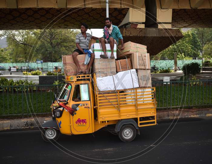 Laborers travel atop a transport vehicle, in Vijayawada.
