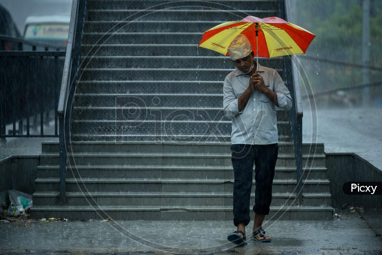 a man walks with an umbrella as it rains heavily in KPHB, Hyderabad, May 31, 2020.