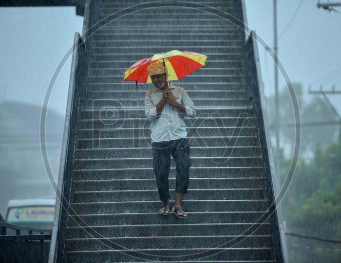 a man walks with an umbrella as it rains heavily in KPHB, Hyderabad, May 31, 2020.