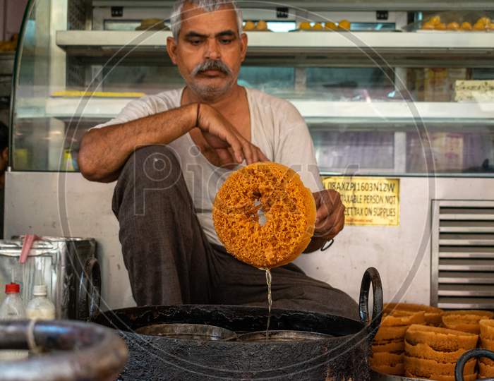 A man prepares Ghevar (Rajasthani cuisine sweet traditionally associated with the Teej Festival) at a shop in Jaipur, March 2019