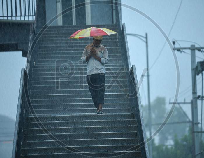 A man walks with an umbrella as it rains heavily in KPHB, Hyderabad, May 31, 2020