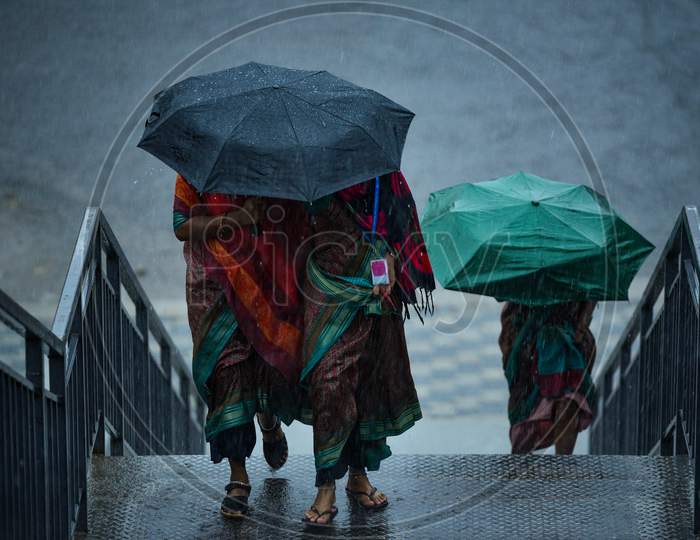 Women walk under an umbrella as it rains Heavily in KPHB,Hyderabad, May 31, 2020