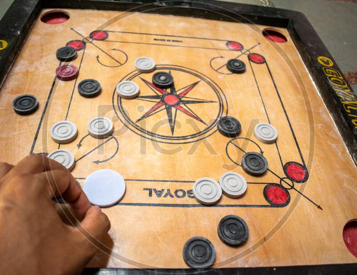 carrom board players playing the game at home