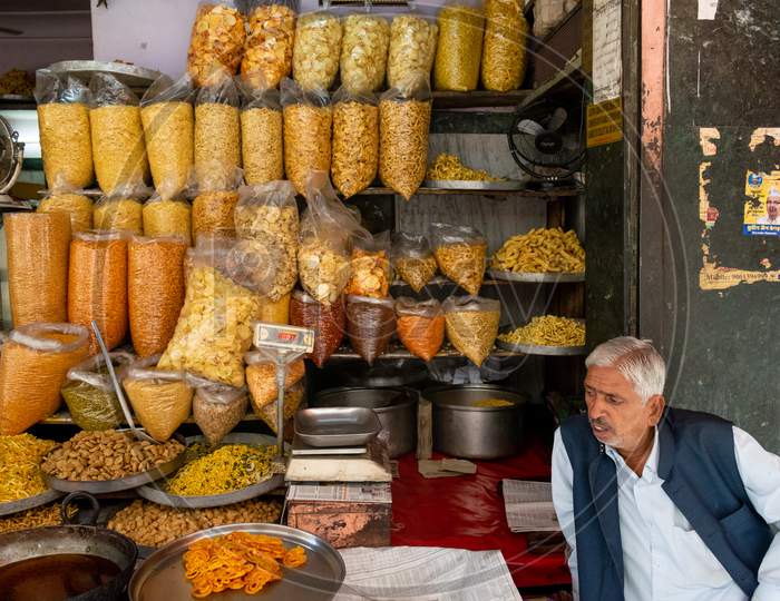 snacks or namkeen and sweets are being sold at a shop and a man sitting outside the shop in Jaipur, March , 2019