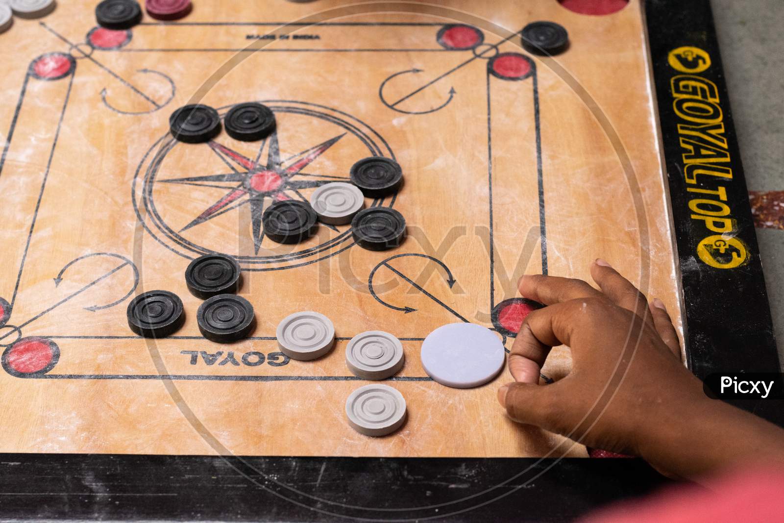 carrom board players playing the game at home