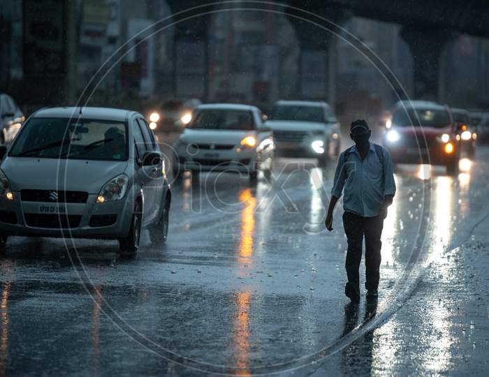 A man walks on road in heavy rain in KPHB, Hyderabad, May 31, 2020