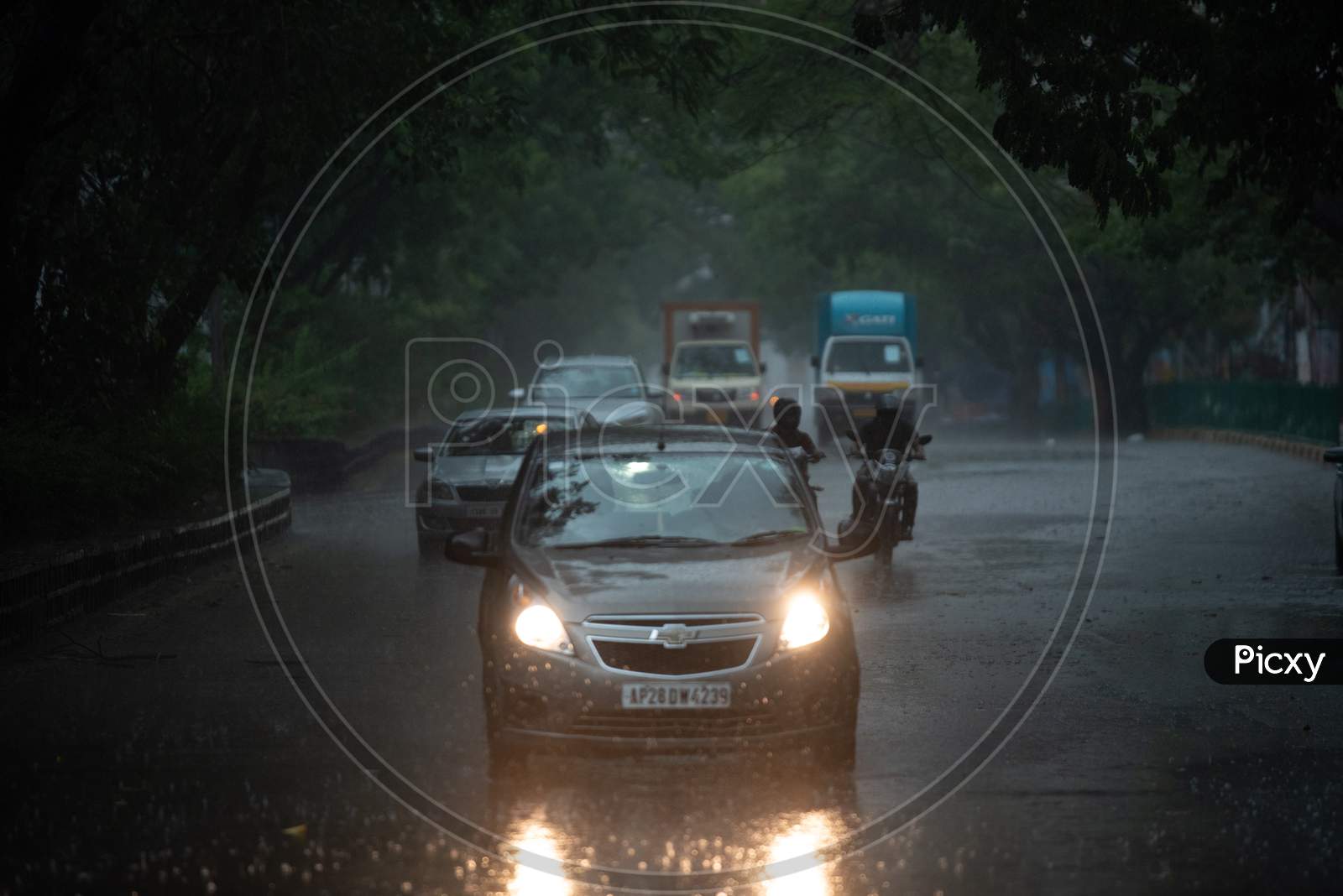 Vehicles ply on KPHB Main road as rain lashes heavily along with gusty winds on May 31, 2020, Hyderabad