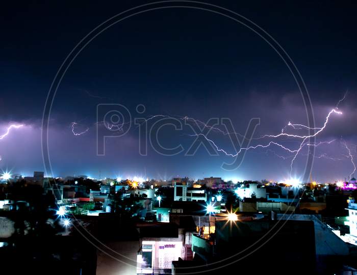 Thunderstorm in night sky of city in moonsoon