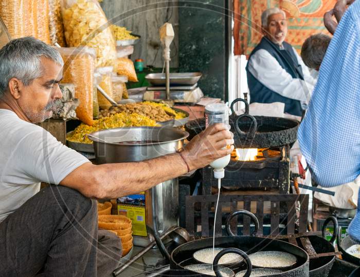 A man prepares Ghevar (Rajasthani cuisine sweet traditionally associated with the Teej Festival) at a shop in Jaipur, March 2019