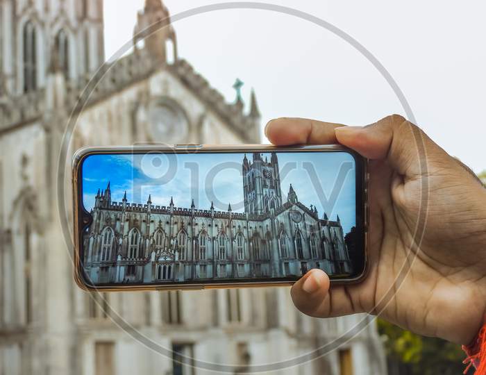 St. Paul's Cathidral in Kolkata, West Bengal, India. August 3, 2019. Church is being photographed holding the phone in hand.