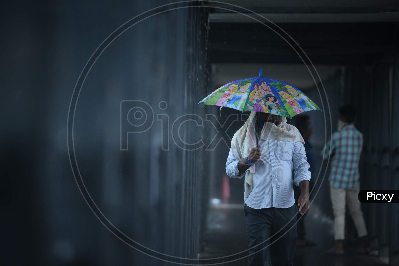 A man carries an umbrella as he walks on a foot over bridge, May 31, 2020.