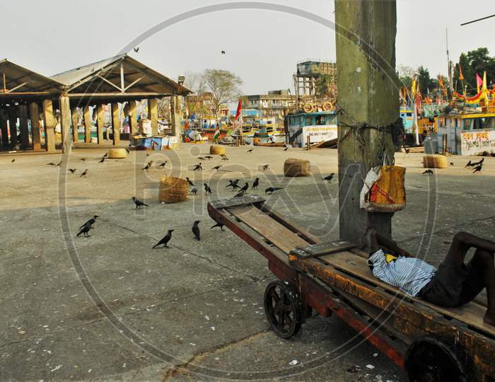A man is seen sleeping on the cart at the deserted Sassoon Docks(Fish market) after the extension of the 21- day nationwide lockdown to limit the spreading of coronavirus disease (COVID-19) in Mumbai, India, on April 15, 2020.