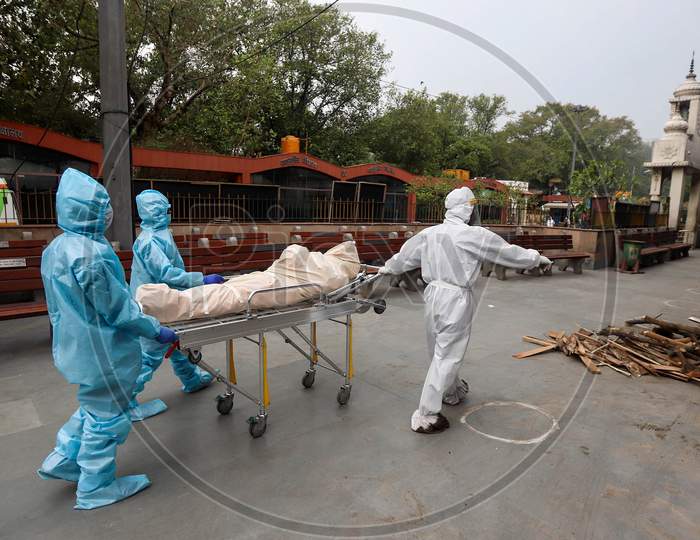 Relatives Of The Deceased Covid-19 patient Wear Hazmat Suits to Perform The Last Rites At Nigambodh Ghat, On May 31, 2020 In New Delhi, India.