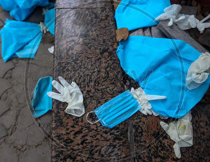 Discarded Latex Gloves, Surgical Masks And Ppe Suits Lie On The Ground after the cremation of a Deceased Covid-19 patient At  Nigambodh Crematorium In New Delhi, India On May 31, 2020.