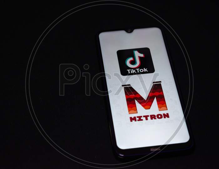 Mitron application and Chinese application tiktok logo on a phone. Both applications are video content creation applications