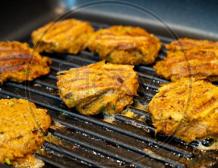 Shallow Depth Of Field Shot Mince Meat Mutton Patties Keema Roasting On A Pan With Oil Bubbling Out As They Get Charred